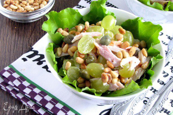 На дно салатника или тарелки положить салатные листы (подойдет любой листовой салат). Выложить приготовленный салат, полить заправкой и посыпать кедровыми орешками.