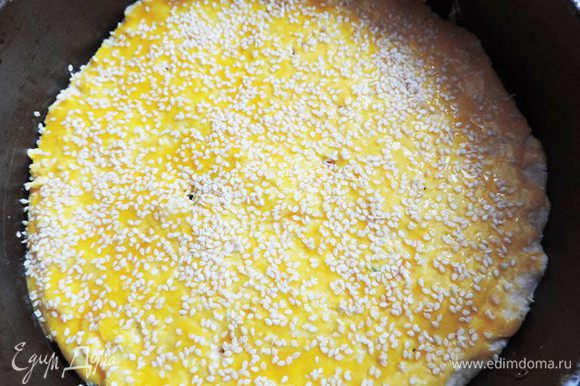 Смазываем верх пирога желтком и посыпаем кунжутом.