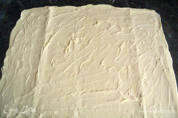 Слоеное тесто разморозить и раскатать в пласт толщиной 3-4 мм, смазать майонезом.