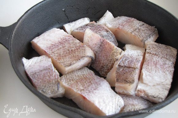 Филе рыбы нарезать кусочками, обсушить бумажным полотенцем. Выложить в чугунную сковороду или огнеупорную форму.