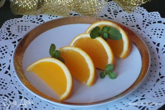 Аккуратно разрежьте фрукты с желе на дольки и подавайте на стол, украсив листочками мяты.