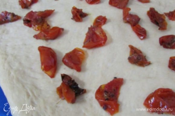 Вяленые помидоры порезать на кусочки и выложить на тесто.