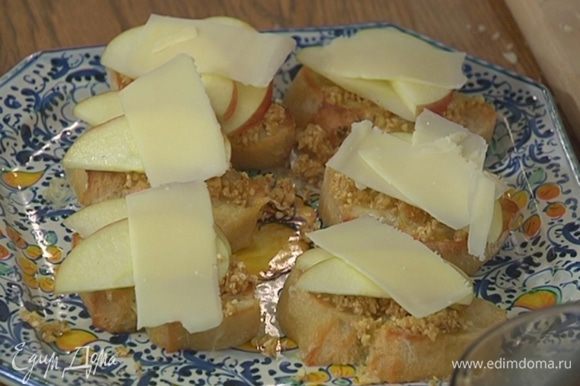 Горячую брускетту смазать орехово-инжирной пастой, на каждый кусочек выложить по паре долек яблока, а сверху — ломтик сыра.