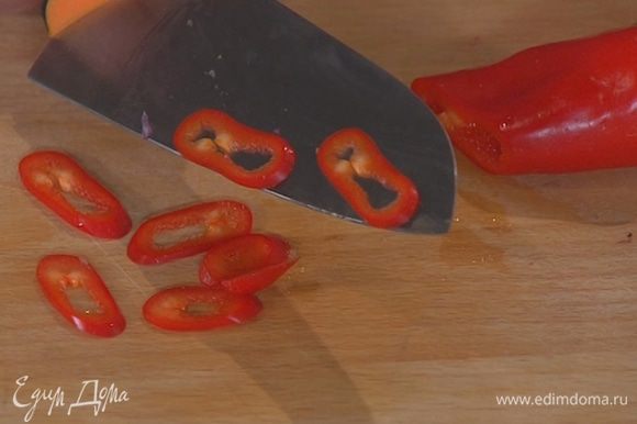Свежий перец чили порезать тонкими кольцами и добавить в сковороду.