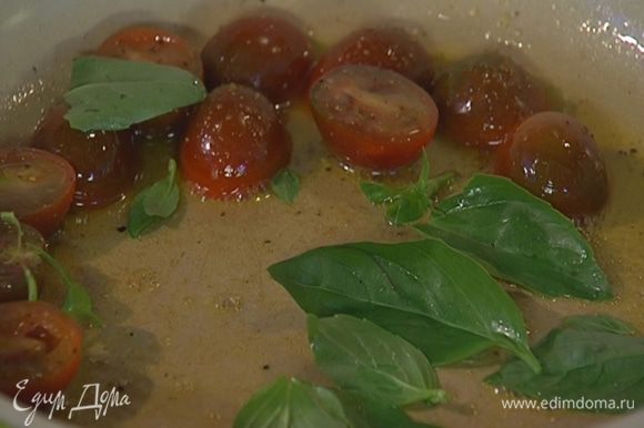 Листья базилика добавить к помидорам и еще несколько секунд держать на огне, затем переложить овощи вместе с маслом в другую посуду.