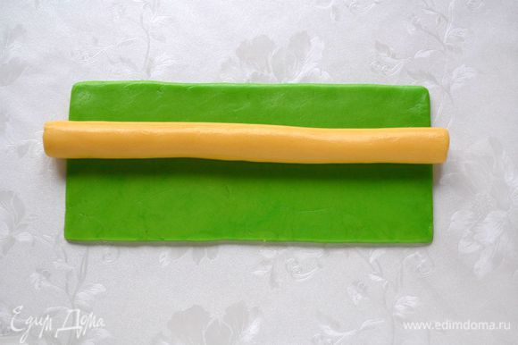 Из светлого теска раскатать колбаску длинной 25 см, выложить на зеленый прямоугольник.