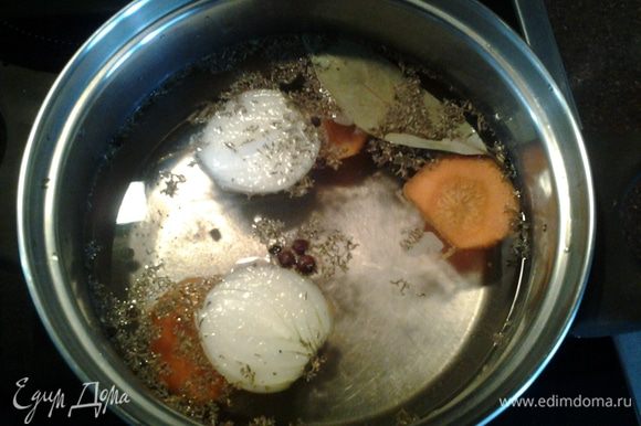 В воду добавить соль, специи, лимонный сок, лук, морковь. Поставить на огонь, довести до кипения.