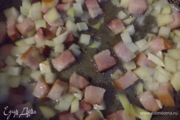 Бекон нарезать кубиками и обжарить на сухой сковороде до появления румяной корочки. Добавить рубленый лук и обжарить его до полупрозрачности.