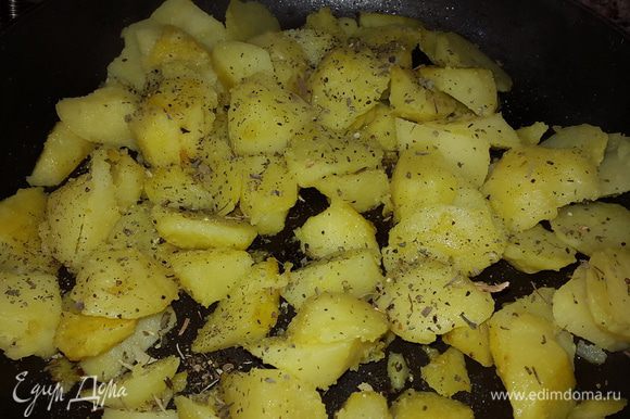 Когда картофель поджарится, немного солим, посыпаем сушеным базиликом, перемешиваем.