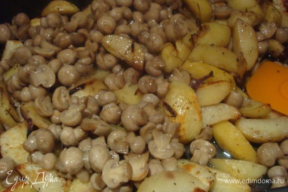 Когда картошка подрумянится, добавьте грибы, хорошо перемешайте. Посыпьте травами, если нужно, еще посолите.