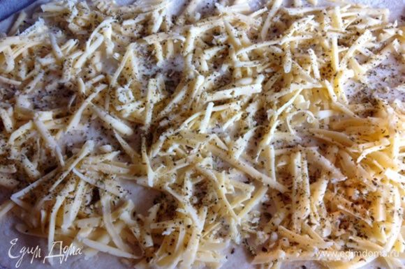 Раскатываем корж толщиной 0,5 см, посыпаем тертым сыром и сухим базиликом, если его нет, можно заменить на "итальянские травы".