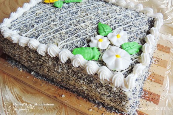 Далее отсадить бордюрчик из крема, растопленным белым шоколадом нарисовать полоски и украсить торт цветочками из айсинга. Вы можете оформить торт по своему вкусу и желанию.