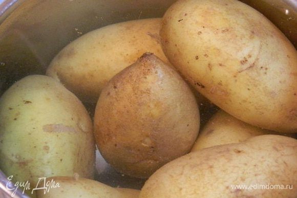 Картофель хорошо помыть с щеточкой. Сложить в кастрюлю, залить водой и отварить до готовности. Остудить и разрезать на две части вдоль.