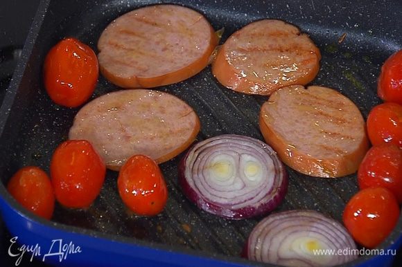 Нарезанную колбасу и лук выложить в сковороду с помидорами и обжарить, затем переложить все на тарелку.