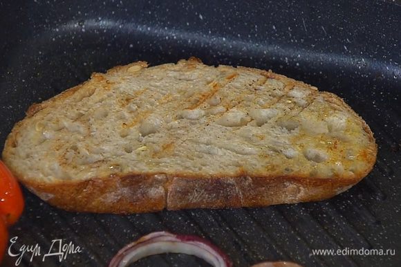 Хлеб обжарить с двух сторон на сковороде-гриль, где жарилась колбаса с луком и помидорами.