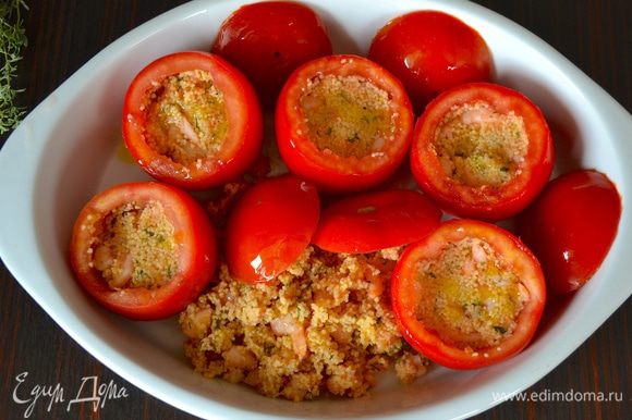 Выложить помидоры в огнеупорную формы, "крыжечки" от помидоров положить рядом, выложить также оставшийся кускус. Сбрызнуть все слегка оливковым маслом. Поставить в разогретую до 190°C духовку на 30 минут.