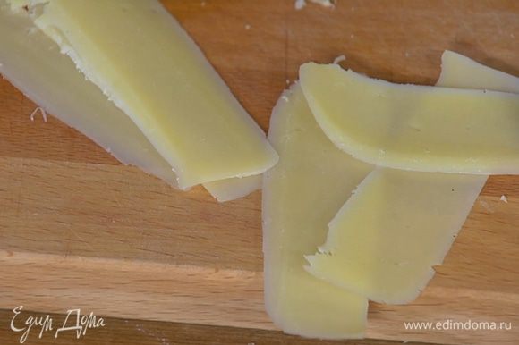 Сыр нарезать тонкими хлопьями (можно использовать овощечистку).