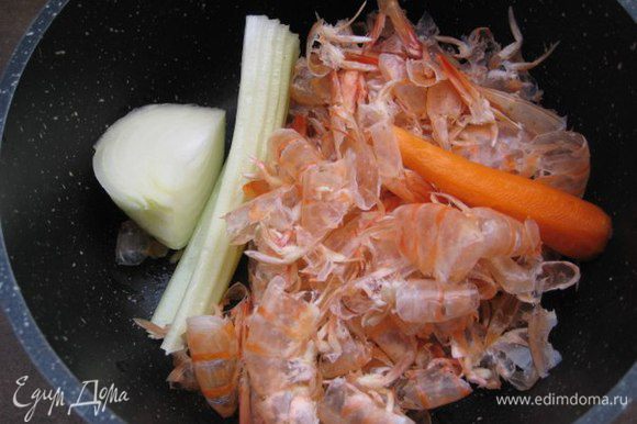 Рыбный бульон: в кастрюлю сложить панцири и головы креветок, полстебля сельдерея, маленькую очищенную морковь, половину небольшой луковицы. Залить 2 л холодной водой, довести до кипения и варить 20 минут. Посолить.