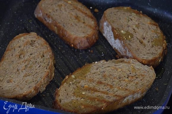 Разогреть в сковороде-гриль оливковое масло и обжарить хлеб с двух сторон.