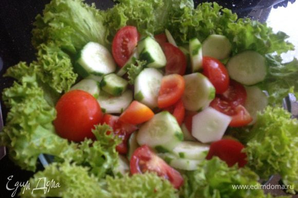 Разложите листья салата в глубокой миске, выложите огурцы с помидорами, посолите и приправьте перцем.
