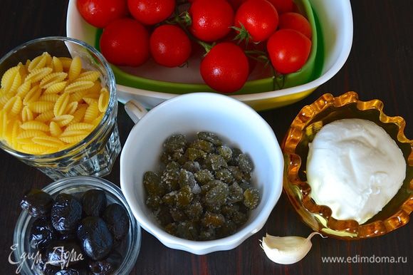 Необходимые ингредиенты - паста, которая называется ньоккетти по-сардински (gnocchetti sardi), можно заменить на любую фигурную пасту небольшого формата, помидорки черри, маслины, каперсы в соли (промыть), моцарелла, зубчик чеснока (по желанию), зелень петрушки (но лучше базилик!).