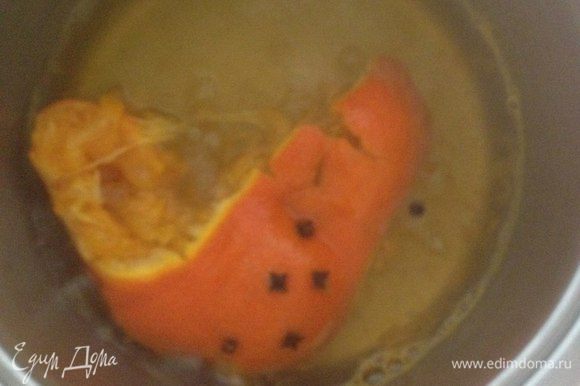 Когда мандарин окрасит воду, отдаст аромат специй, выдавливаем ложкой оставшийся в нём сок и даем немного остыть.