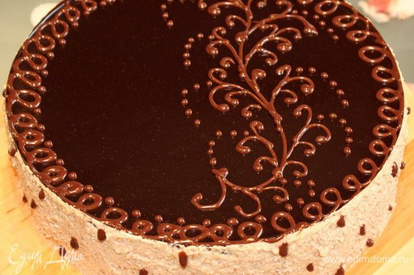 Шоколадный декор. Молочный шоколад растапливаем на водяной бане. Сливки подогреваем до хорошего теплого состояния, но не кипятим, а то они свернуться. Соединяем сливки и растопленный шоколад. Делаем корнет из пергамента и заполняем его шоколадом. Достаем торт из холодильника, обрабатываем бока оставшимся кремом и наносим шоколадный декор. Убираем в холод на пару часов.