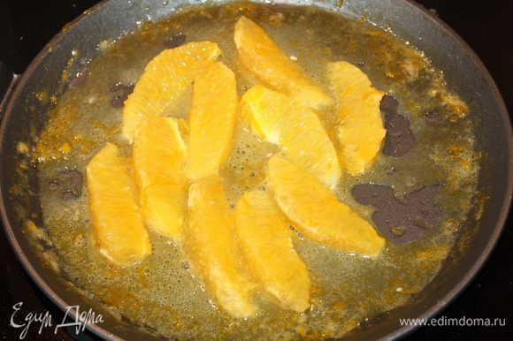 Апельсиновые дольки опускаем в соус, даем им хорошо прогреться, а затем выкладываем на блины.