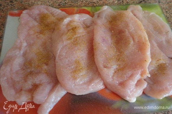 Куриные грудки разрезать вдоль пополам, завернуть в пищевую пленку и отбить. Затем натереть солью и специями.
