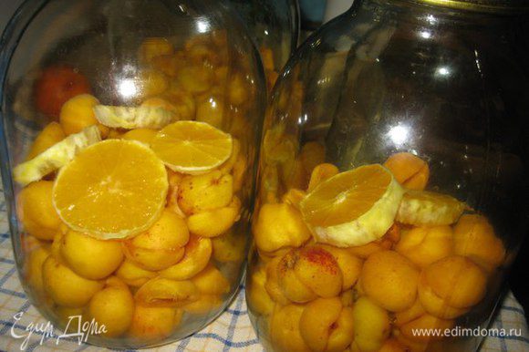 В чистые, сухие и стерилизованные банки складываем абрикосы и апельсины.