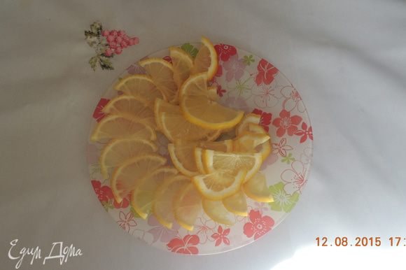 Нарежьте лимоны тонкими ломтиками.