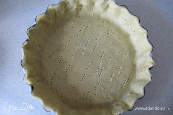Охлажденное тесто раскатать между двумя листами пергамента. Выложить тесто в форму для тарта, распределить по всей форме, излишки теста удалить. Наколоть тесто по всей поверхности вилкой и отправить в холодильник еще на 30 мин.