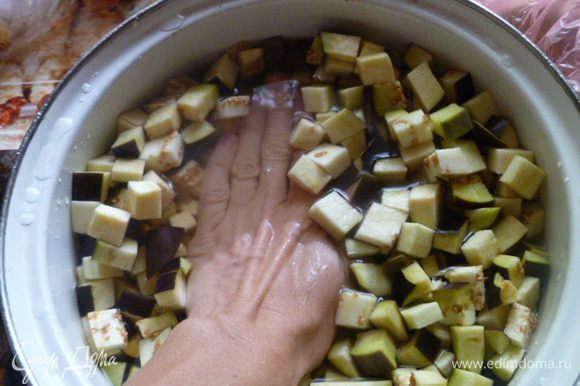 Баклажаны помыть, отрезать плодоножки и нарезать кубиками. Баклажаны залить водой так, чтобы они были покрыты на 1-2 см. Добавить соль.