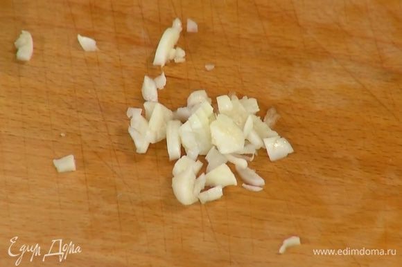 Оставшийся зубчик чеснока раздавить плоской стороной ножа, мелко порубить, добавить в сковороду с луком и обжаривать еще 4–5 минут.