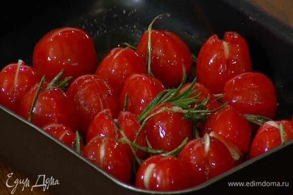 Выложить помидоры в небольшой противень, посыпать листьями розмарина, посолить, поперчить и полить оливковым маслом.