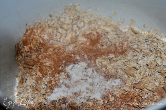 Тем временем займемся сухой смесью. В миске смешиваем геркулес, разрыхлитель и половину арахиса. Добавляем оставшуюся корицу.