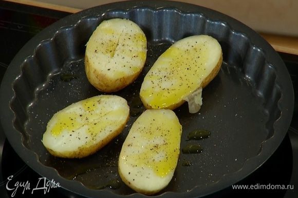 Готовый картофель разрезать вдоль пополам, выложить в небольшой противень, сбрызнуть оливковым маслом, немного посолить и поперчить, отправить в разогретую духовку и прогреть.