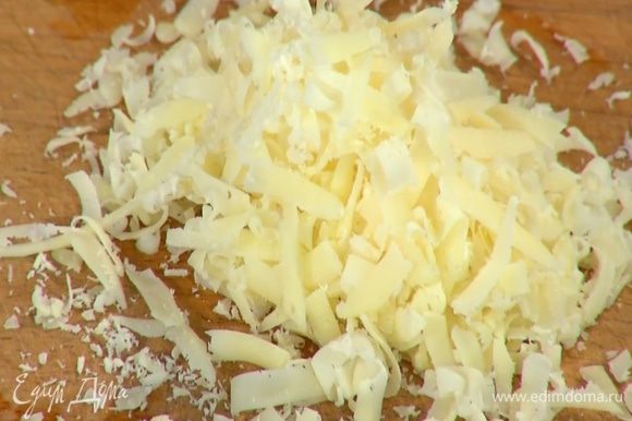 Сыр натереть на крупной терке, добавить в тесто и перемешать.