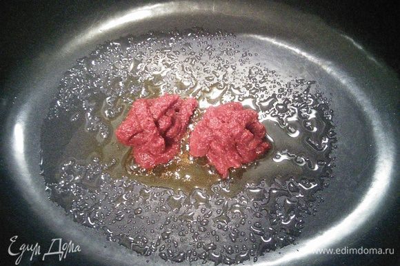 В емкость, в которой вы будете запекать мясо, всыпать сахарную пудру и закарамелизировать, добавить томатную пасту, перемешать и обжарить до золотисто-коричневого цвета. Духовку разогреть до 200°С.