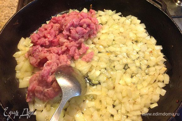 В глубокой сковороде на растительном масле довести лук до прозрачного цвета, затем добавить мясо. Прожарить минут пять на среднем огне.