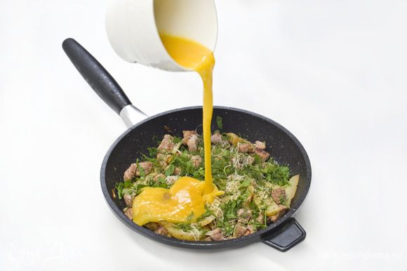 Яйца взбить, посолить, поперчить и вылить на содержимое сковороды. Жарить минут 5-7 минут, пока яйца не запекутся.
