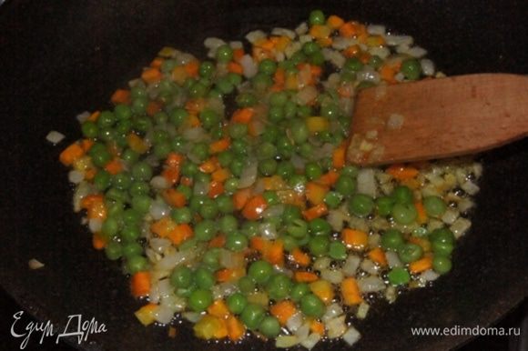 Зеленый горошек (предварительно достать из морозилки) всыпать к луку с морковкой. Готовить еще 10 минут, приправив прованскими травками или любыми на ваш вкус специями.