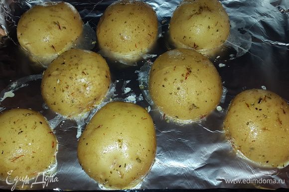 Выкладываем картофель на противень застеленный фольгой срезом вниз и ставим запекаться при температуре 170°C до готовности. Примерно 35 минут.