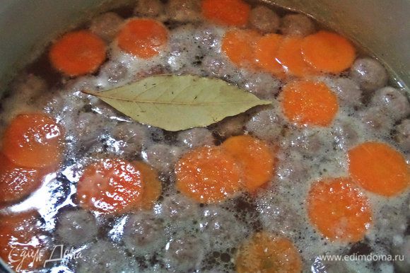 В кипящую воду отправляем фрикадельки, морковь, лаврушку, приправы с солью и перцем.