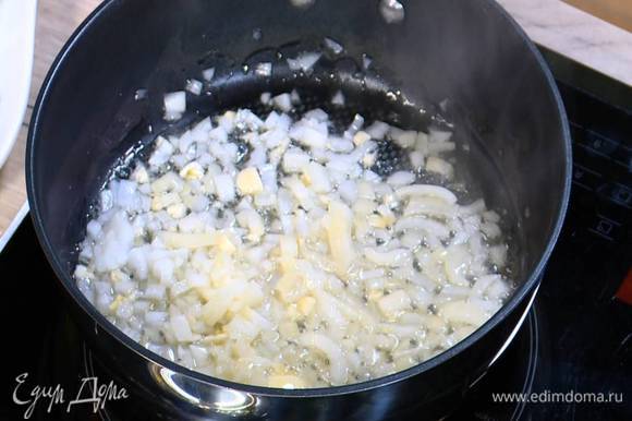 Разогреть в сковороде оливковое и сливочное масло и обжарить лук и чеснок до прозрачности.