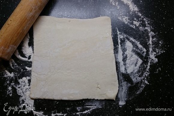 Слоеное тесто разморозить при комнатной температуре. Подпылив стол мукой, чтобы тесто не прилипало, немного раскатать пласт.