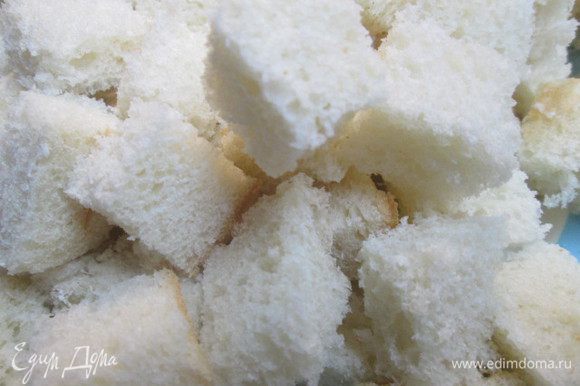 Нарезаем кубиками хлеб. Разогреваем духовку до 175°C. Форму для запекания (лучше круглого размера, диаметром 20 см, или овального), смазываем сливочным маслом. Смешиваем сахар с корицей, изюмом и щепоткой соли.