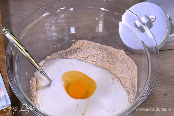 Всю муку соединить, всыпать сахар, соду, соль, влить кефир, добавить яйцо и все перемешать.