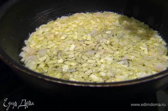 Разогреть в сковороде немного оливкового масла и обжарить лук до прозрачности, затем добавить измельченный чеснок, перемешать и тушить на небольшом огне.
