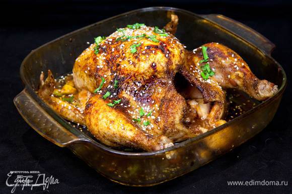 Проверить готовность курицы. Если курица готова, то смазать остатками глазури, посыпать луком и кунжутом. Блюдо готово.